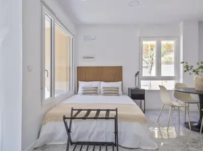 a bedroom with a large bed with a table and chairs at Loft Temporal a 2 min de Playa de Sagunto A1 in Puerto de Sagunto