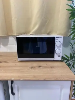 a microwave sitting on top of a wooden table at ALZIRA BONITA Apto con terraza y cama balinesa les barraques in Alzira