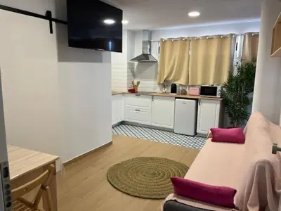 a living room with a couch and a kitchen at ALZIRA BONITA APARTAMENTO CON TERRAZA Y JACUZZi EXTERIOR in Alzira