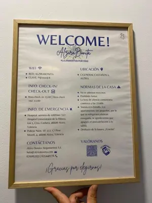 a person holding up a sign with a welcome menu at ALZIRA BONITA APARTAMENTO CON TERRAZA Y JACUZZi EXTERIOR in Alzira