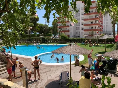 a group of people in a swimming pool at Estupendo apartamento con piscina y vistas al mar in Cullera