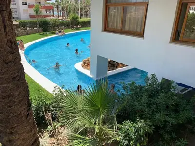a group of people swimming in a swimming pool at Estupendo apartamento con piscina y vistas al mar in Cullera
