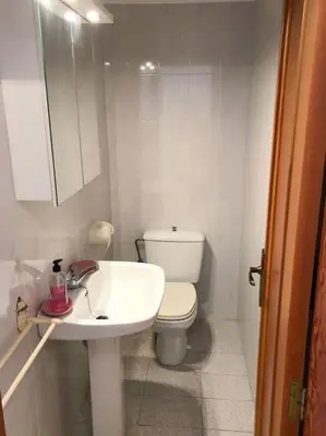 a white bathroom with a toilet and a sink at Estupendo apartamento con piscina y vistas al mar in Cullera