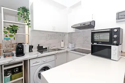 a white kitchen with a sink and a microwave at GuestReady - Apartamento en Benicalap in Valencia