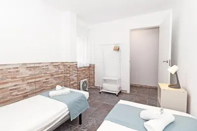 a bedroom with two beds and a brick wall at GuestReady - Apartamento en Benicalap in Valencia