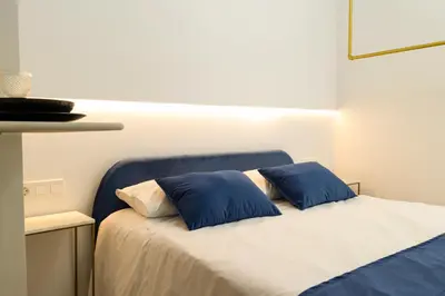 a bedroom with a bed with two blue pillows at Forata lofts in Valencia