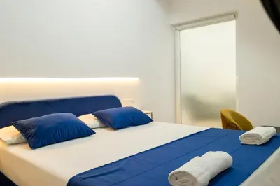 a bedroom with a bed with blue and white pillows at Forata lofts in Valencia