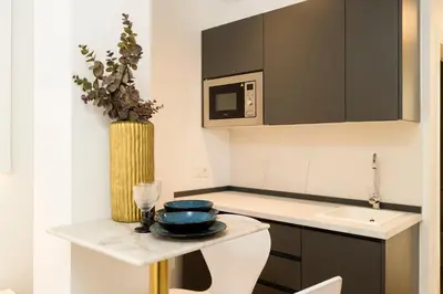 a small kitchen with a table and a microwave at Forata lofts in Valencia