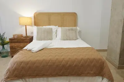 a bed with a brown blanket and pillows at Loft 9 in Valencia