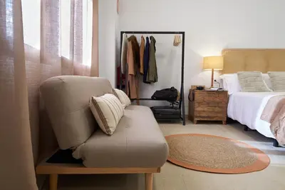 a bedroom with a bed and a chair with a pillow at Loft 9 in Valencia