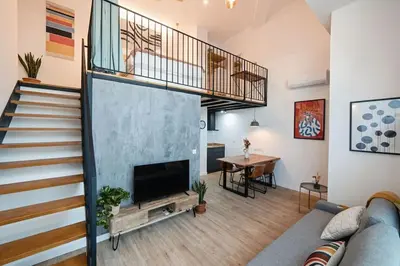 a living room with a staircase and a television at Lofts JM Orense D Amplio y cercano a la playa in Valencia