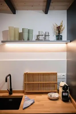 a kitchen with a sink and a shelf with cups at Lofts JM Orense D Amplio y cercano a la playa in Valencia