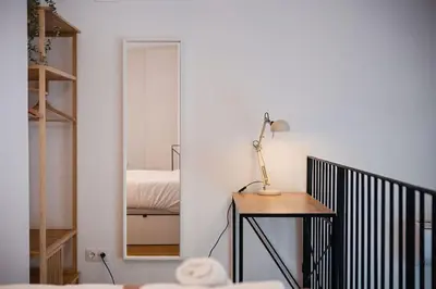 a room with a table and a mirror and a bed at Lofts JM Orense D Amplio y cercano a la playa in Valencia