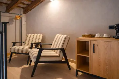 a living room with two chairs and a table and a lamp at Tradere Hotel Boutique in Moncada