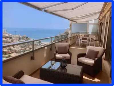 a balcony with chairs and a table and the ocean at Espectacular apartamento en Cullera con vistas al mar in Faro de Cullera
