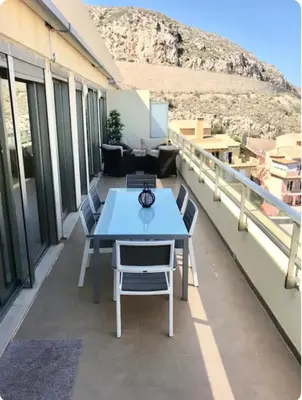 a patio with a blue table and chairs on a balcony at Espectacular apartamento en Cullera con vistas al mar in Faro de Cullera