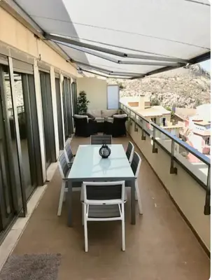 a room with a table and chairs on a balcony at Espectacular apartamento en Cullera con vistas al mar in Faro de Cullera