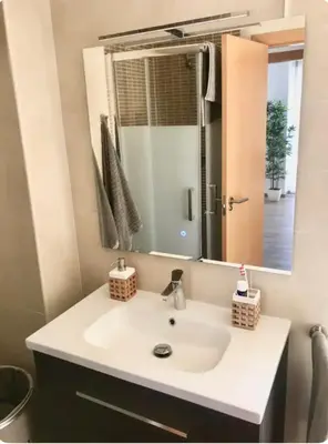 a bathroom with a white sink and a mirror at Espectacular apartamento en Cullera con vistas al mar in Faro de Cullera