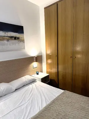 a bedroom with a white bed and a wooden cabinet at Guillem Silence in Valencia
