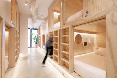 a person walking through a room with bunk beds at Colo Colo Hostel Valencia - Single Private Beds in Valencia
