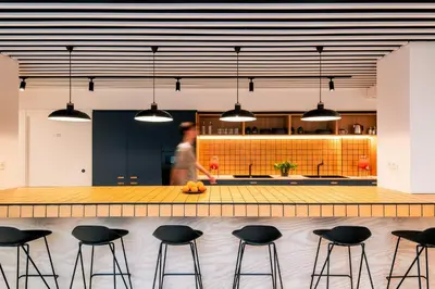a man in a kitchen with a counter and stools at Colo Colo Hostel Valencia - Single Private Beds in Valencia