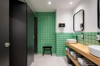 a green tiled bathroom with a sink and a mirror at Colo Colo Hostel Valencia - Single Private Beds in Valencia