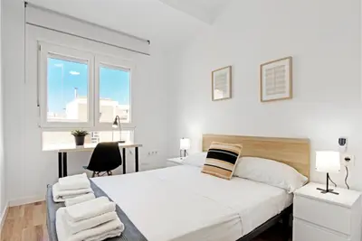 a bedroom with a bed and a desk and a window at Apartamento 4 habitaciones y 2 baños in Puerto de Sagunto