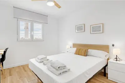 a white bedroom with a bed with towels on it at Apartamento 4 habitaciones y 2 baños in Puerto de Sagunto