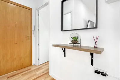 a hallway with a wooden shelf and a mirror at Apartamento 4 habitaciones y 2 baños in Puerto de Sagunto