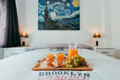 a tray of fruit and orange juice on a bed at Apt Cabanyal, Beach 8 Min, Terrace, Smart TV in Valencia