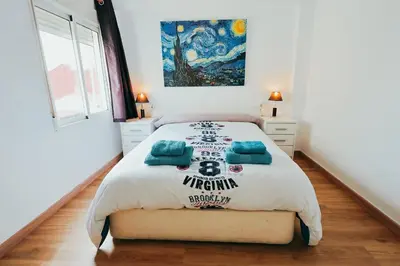 a bedroom with a bed and a painting on the wall at Apt Cabanyal, Beach 8 Min, Terrace, Smart TV in Valencia