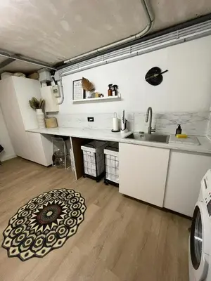 a kitchen with white cabinets and a sink and a rug at CASA Silvestre in La Eliana