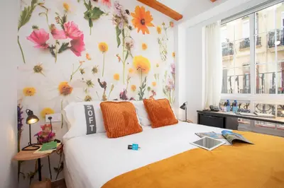 a bedroom with a bed with flowers on the wall at Casual Natura Valencia in Valencia