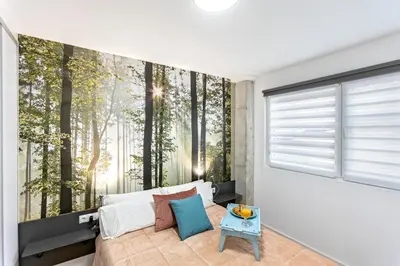 a bedroom with a wall mural of trees at Apartamento Beniloft - Housevanlive in Valencia
