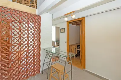 a dining room with a glass table and a brick wall at GuestReady - Charming stay in the Heart of Russafa in Valencia