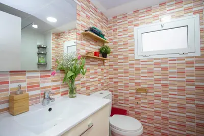 a bathroom with a sink and a toilet and a window at GuestReady - A joyful stay in Poblats Marítims in Valencia