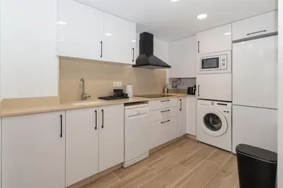 a kitchen with white cabinets and a washer and dryer at GuestReady - Superb retreat in Ruzafa in Valencia
