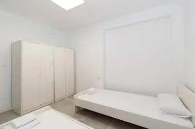 a white room with a bed and a cabinet at GuestReady - A lovely gem near La Malvarrosa beach in Valencia