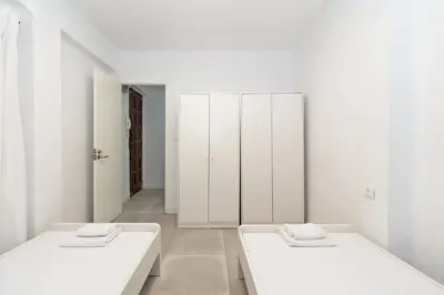 two beds in a room with white cabinets at GuestReady - A lovely gem near La Malvarrosa beach in Valencia