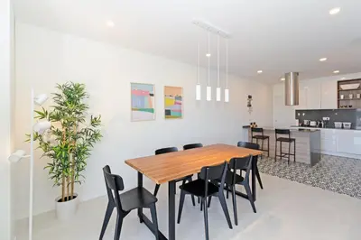 a kitchen and dining room with a wooden table and chairs at GuestReady - Piso moderno con vistas a la Marina in Valencia