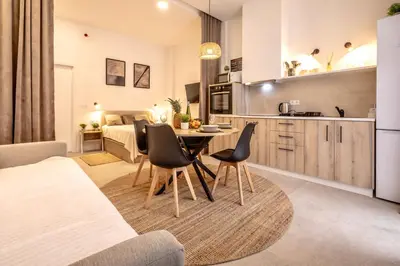 a kitchen and living room with a table and chairs at Чудовий новий Лофт поруч з містом наук in Valencia