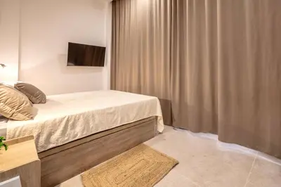 a small bedroom with a bed and a television at Чудовий новий Лофт поруч з містом наук in Valencia