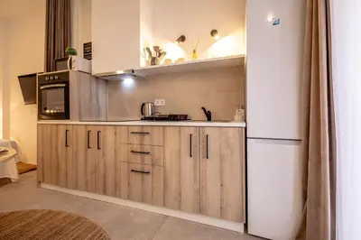 a kitchen with wooden cabinets and a white refrigerator at Чудовий новий Лофт поруч з містом наук in Valencia