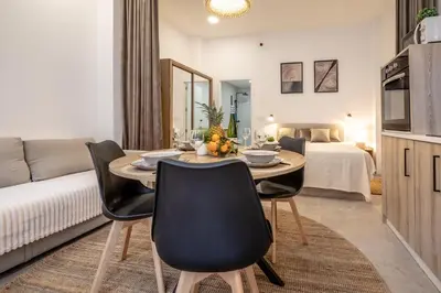 a living room with a table and chairs and a bed at Чудовий новий Лофт поруч з містом наук in Valencia