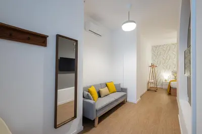 a living room with a couch and a mirror at FLORIT FLATS - The Maritim Metro Station Suites in Valencia