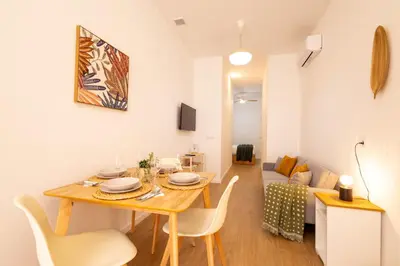 a dining room and living room with a table and chairs at FLORIT FLATS - The Maritim Metro Station Suites in Valencia