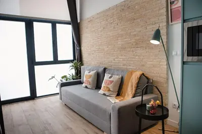 a living room with a couch and a brick wall at Lofts plaza JM Orense C in Valencia