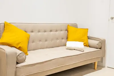 a couch with two yellow pillows on it at VLC HOST- Islas Canarias in Valencia