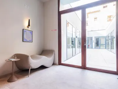 a living room with a chair and a sliding glass door at Numa Valencia La Xerea in Valencia