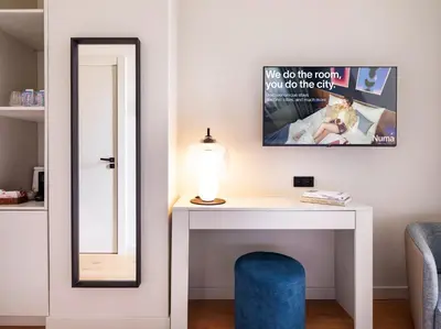 a room with a desk with a mirror and a lamp at Numa Valencia La Xerea in Valencia